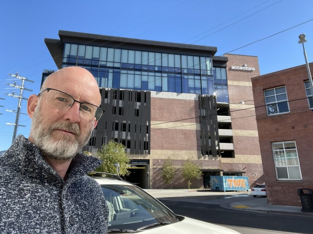 Peter Pendleton in front of a completed parking structure with office floors above