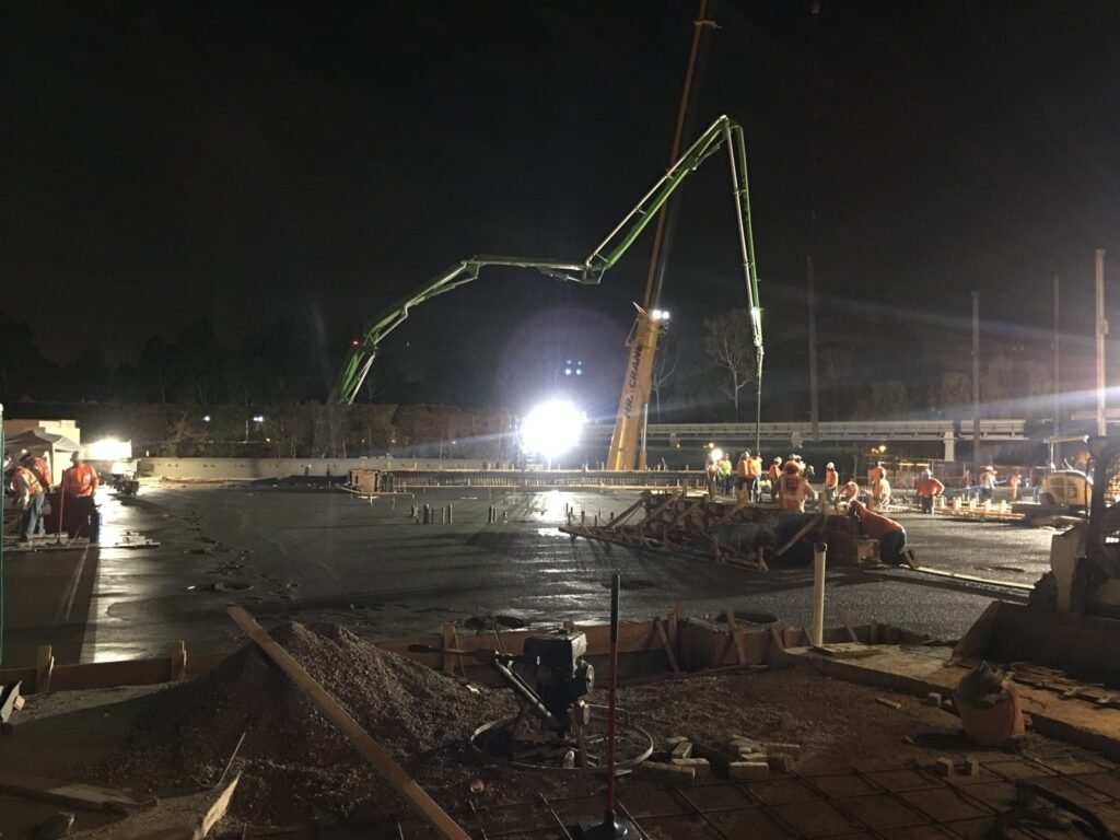 Night concrete pour with a boom pump, crane and crew