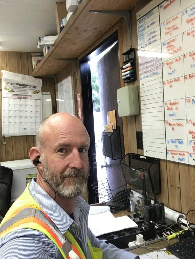 Peter Pendleton in the site trailer by the schedule board