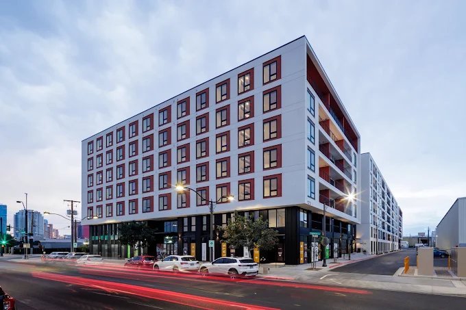 Completed seven-story multifamily building at dusk